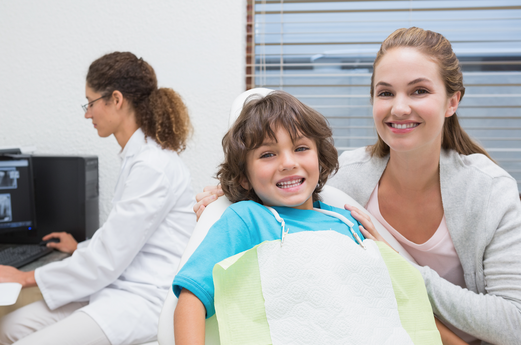 Young boy smiling after fluoride treatment