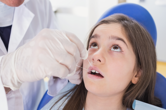 child flossing at dentist